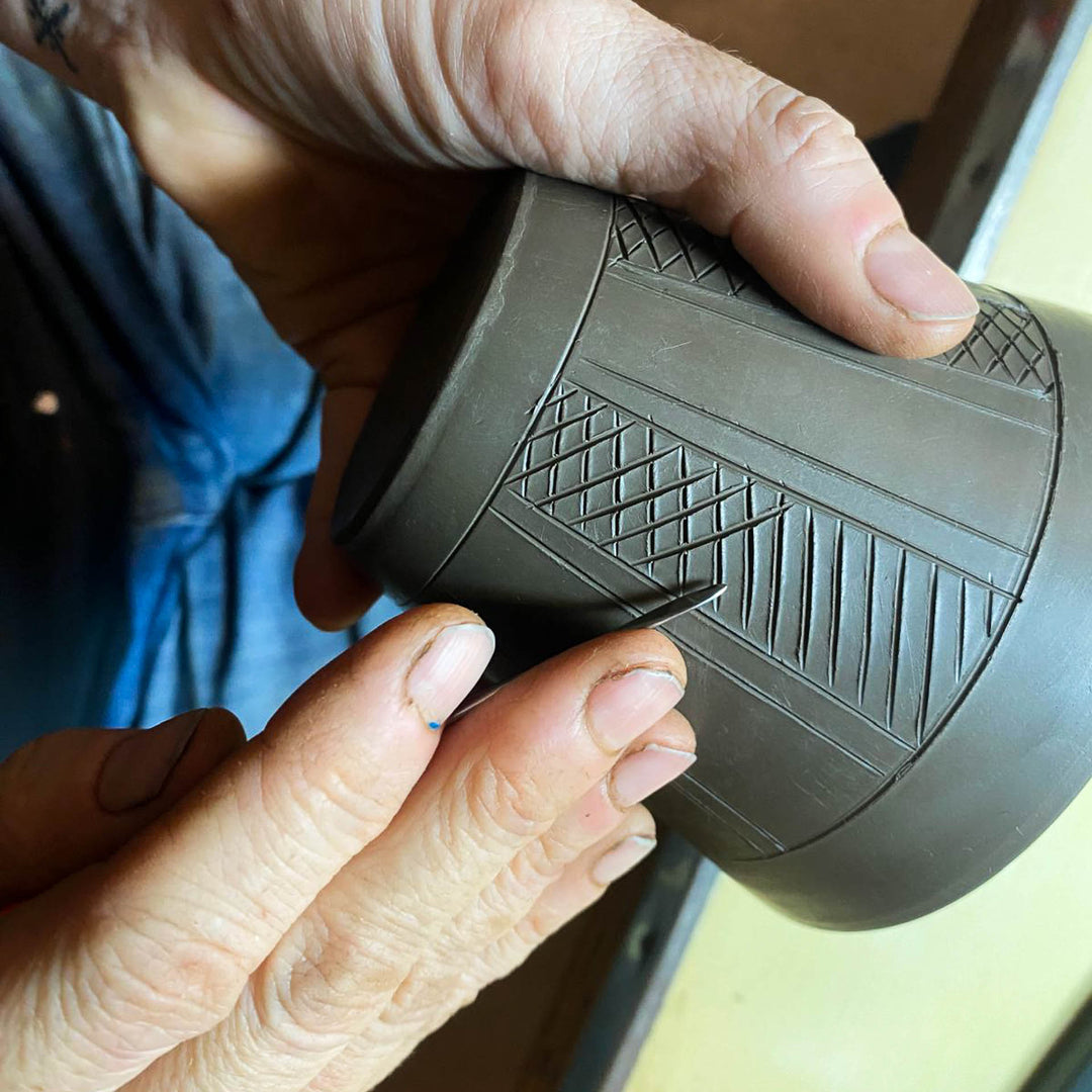 Ceramicist Maggie King incising a cup